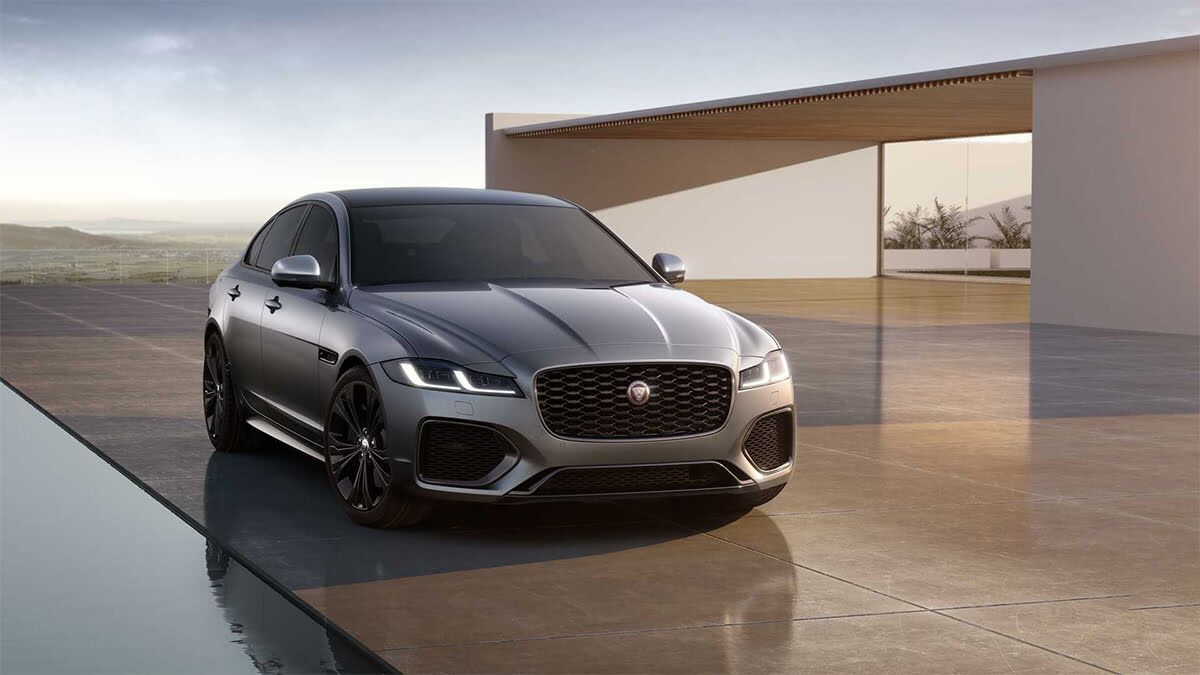 Lüks bir malikanenin önünde park edilmiş gümüş rengi Jaguar F-Pace.